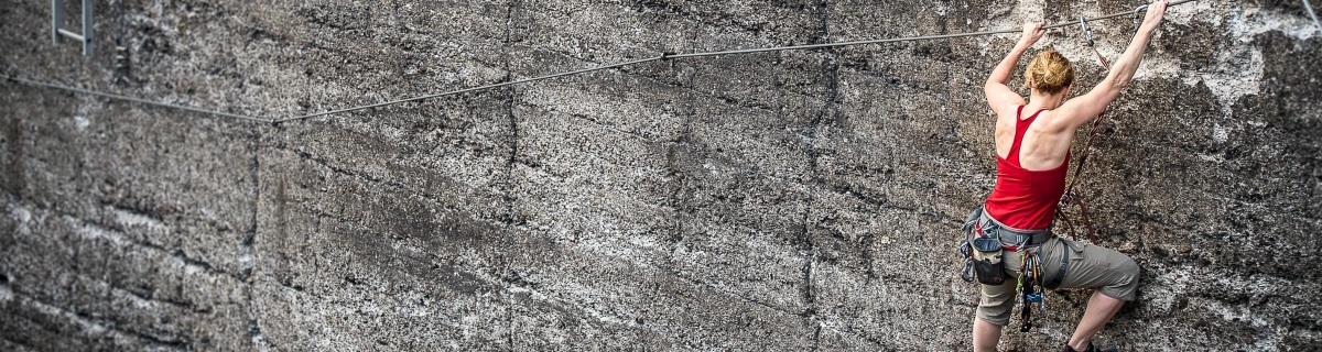 Rock climber scaling cliff face