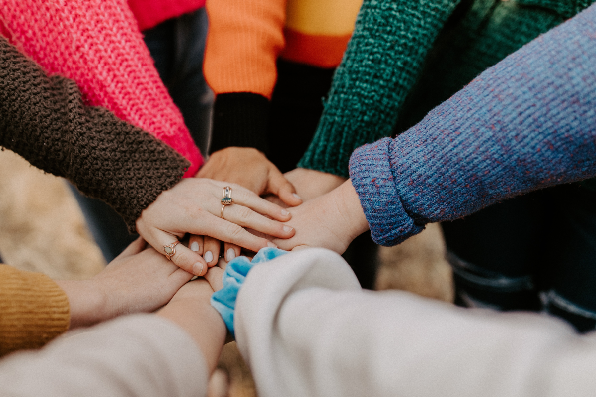 Friends with their hands together.