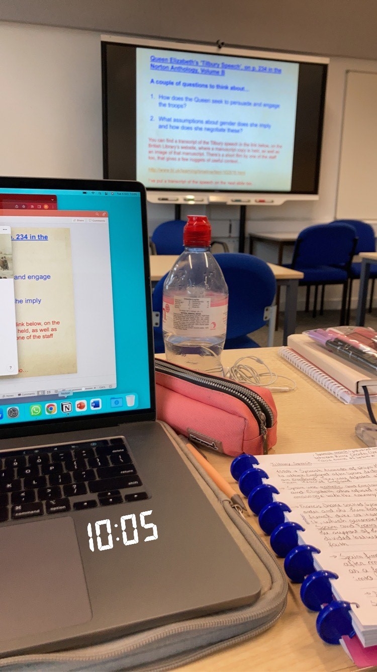 Image of a student's desk with a laptop and notebook in a seminar.