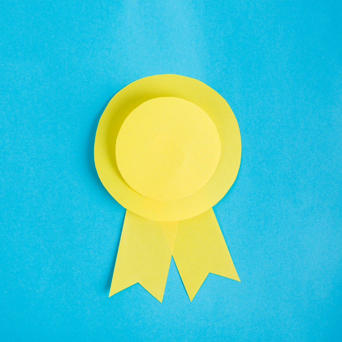 A yellow paper medal against a blue background.