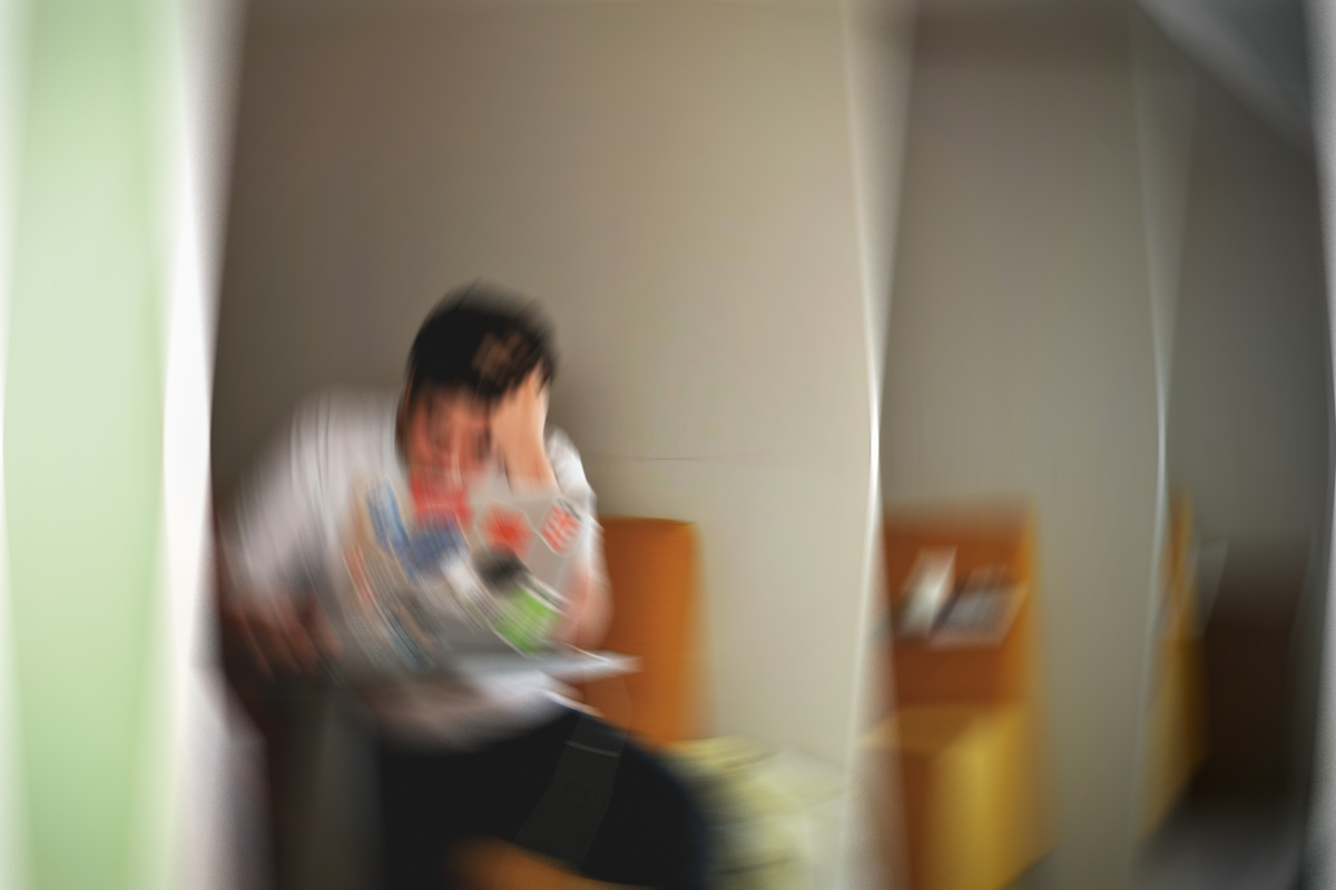 Blurry image of student sat at a desk, stressed.