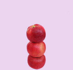Three red apples balancing on top of one another.